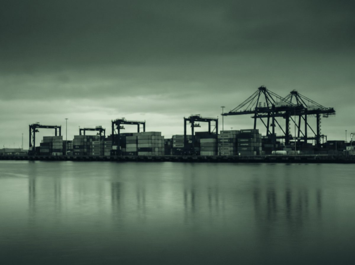 A container terminal at dusk across still water